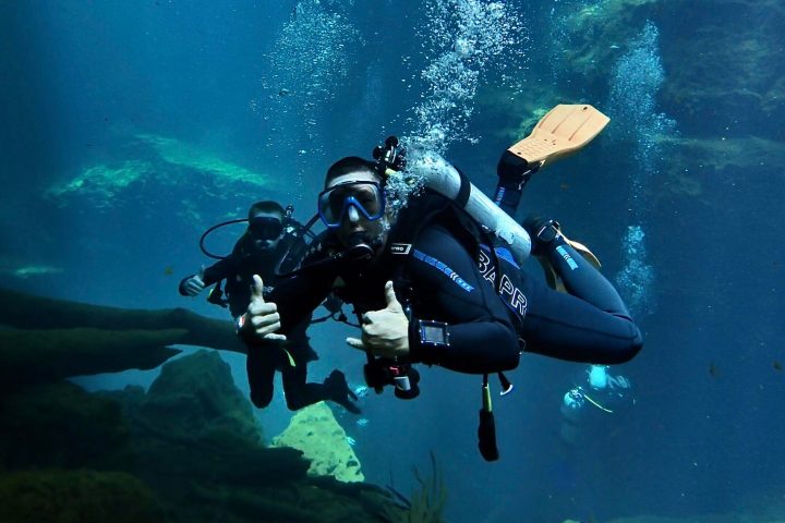 a man riding a motorcycle next to a body of water